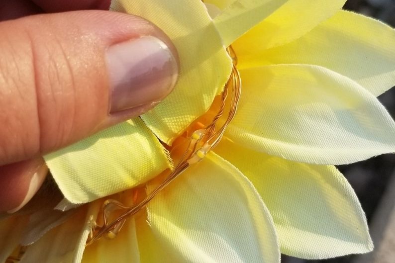 led wire and bulbs in between the petals of a Homeleo solar sunflower