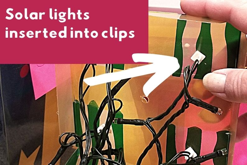 new solar light cord secured in clips of old christmas decoration