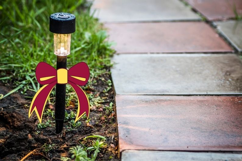 stake light with red and gold bow