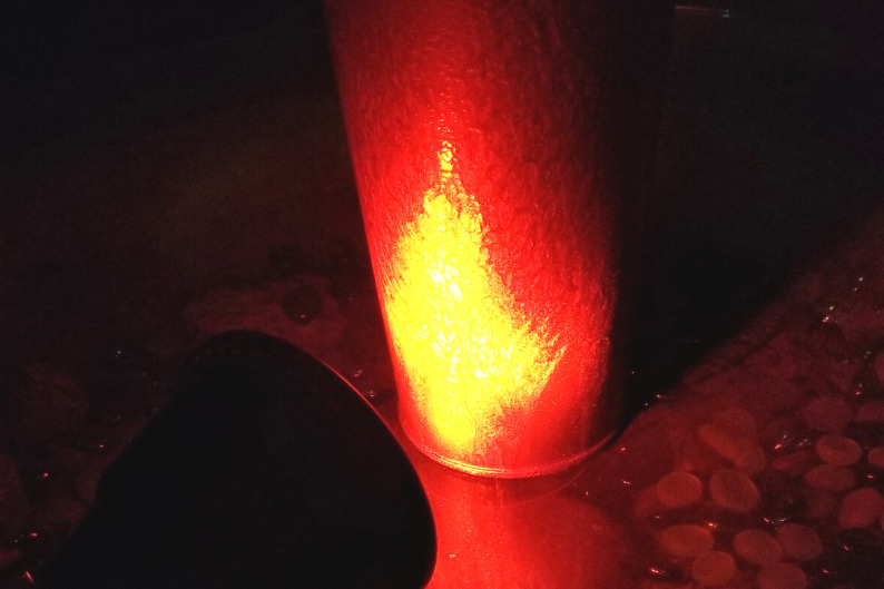 Red solar spotlight pointed at copper surface